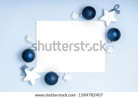 New Year and Christmas frame composition. Blank sheet of paper on blue background. Top view, flat lay, copy space. Template design invitation card. Trendy color of the year 2020..