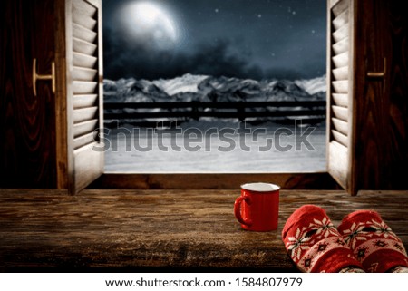 Woman legs on window sill and free space for your decoration.Christmas time and dark december night.Moon with light and sky with stars. 