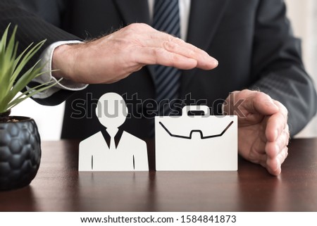 Insurer protecting an employee and a briefcase with his hands Royalty-Free Stock Photo #1584841873