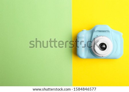 Light blue toy camera on color background, top view with space for text. Future photographer