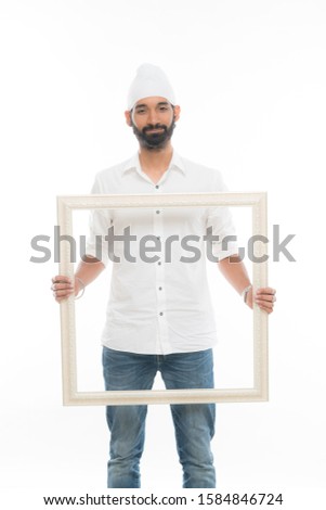 Handsome young man holding a transparent picture frame. 