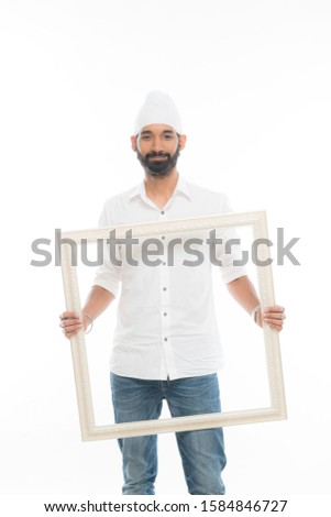 Handsome young man holding a transparent picture frame. 