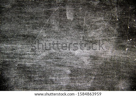 A black background with white texture on it.  A nice black background with a chalk texture on it