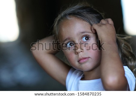 portrait of a beautiful 4 year old girl who loks sideways