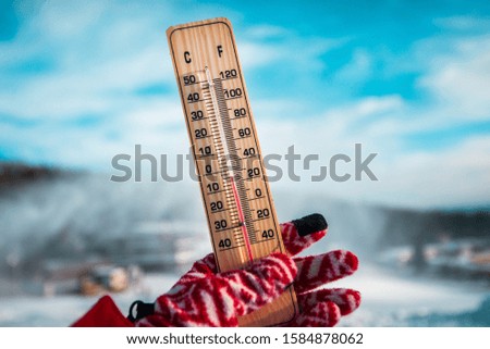 Winter time. thermometer on snow shows low temperatures in celsius or fahrenheit.