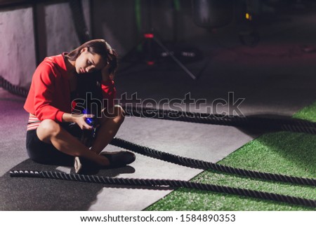Athletic young woman doing some exercises with a rope outdoor.