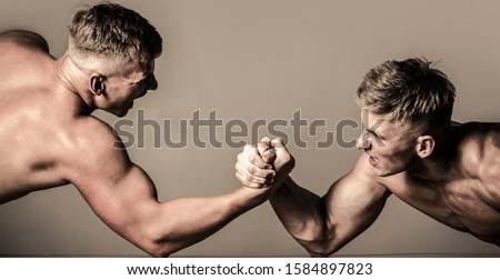 Arm wrestling. Two men arm wrestling. Men measuring forces, arms. Hand wrestling, compete. Rivalry, closeup of male arm wrestling. Hands or arms of man. Muscular hand.