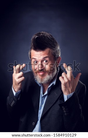 A portrait of funny bearded man with iroquois wearing suit covering showing crossed fingers. People and emotions concept