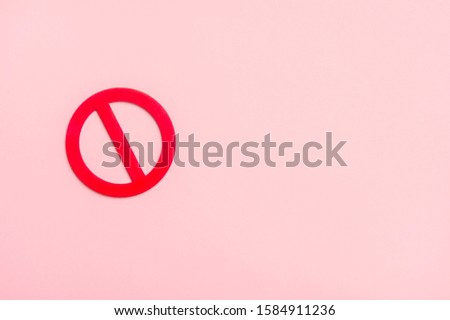 Red forbidden sign on pink background.