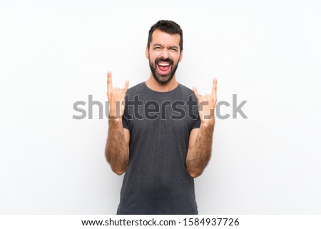 Young handsome man over isolated white background making rock gesture