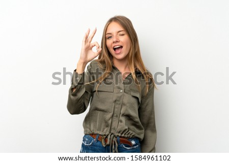 Lithuanian blonde girl over isolated white background surprised and showing ok sign