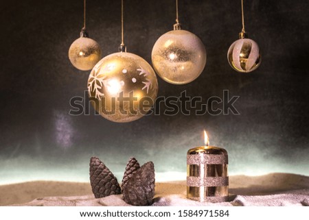 Christmas decoration with burning candles on a dark background. Christmas ornaments over dark golden background with lights. Creative artwork decoration.