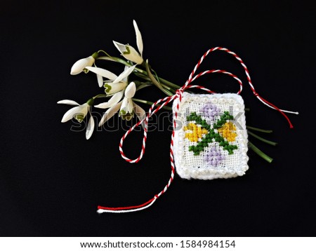 
Traditional sewing pattern with red and white string, known as Martisor. It is a Romanian traditional symbol of the beginning of spring. Isolated on black background.
