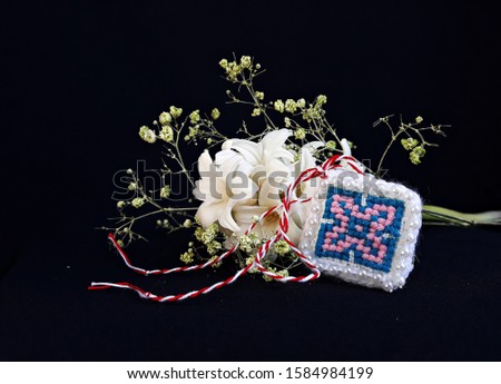 
Traditional sewing pattern on black background and red and white string, known as Martisor. It is a Romanian traditional symbol of the beginning of spring.
