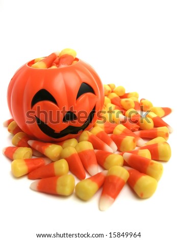 A plastic pumpkin filled with candy corn.