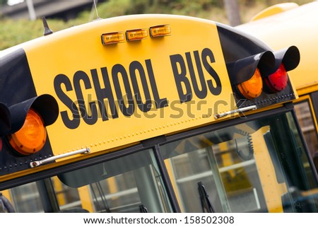 School bus children educational transport sitting in the parking lot waiting to be in service Royalty-Free Stock Photo #158502308