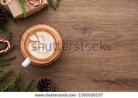 Wood table with cup of latte coffee and Christmas decoration with gift box. Christmas and new year celebration concept. Top view with copy space, flat lay.