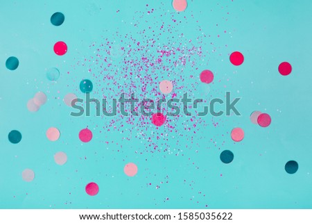 Multicolored paper confetti on blue background