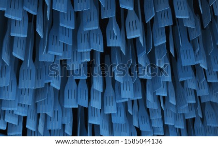 Blue Wooden spoons hanging from the sealing. Cooking spoons pattern. Colored spoons with classic blue color of the year 2020.