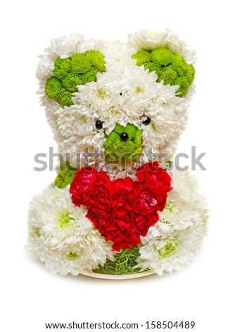 Bear made from flowers holding a red heart. Image isolated on white studio background.
