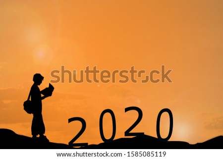 Silhouette boy is standing for plan to 2020 years on the hill over sunset orange sky background, New year 2020 concept.