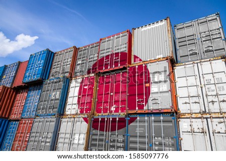The national flag of Japan on a large number of metal containers for storing goods stacked in rows on top of each other. Conception of storage of goods by importers, exporters
