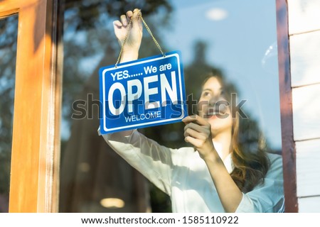 Asian young asian woman setting open sign at the shop glasses for welcome the customer in to the coffee shop, small business owner and startup with cafe shop, installing open and close label concept Royalty-Free Stock Photo #1585110922