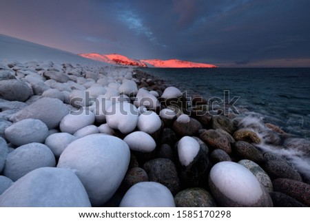 Rocks on the shore covered with ice, Kola Peninsula, Murmansk region, Russia