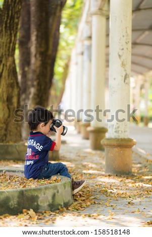 Photographer boy taking photo with toy camera