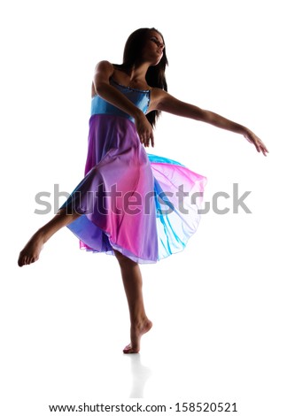 Silhouette of a beautiful female modern jazz contemporary style dancer isolated on a white background. Dancer is barefoot and wearing a blue and purple dress.