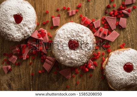 Traditional Hanukkah donuts Sufganiyot on pink ruby chocolate background.
