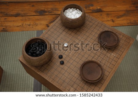 Board game Go. Two cans with black and white stones for the game.