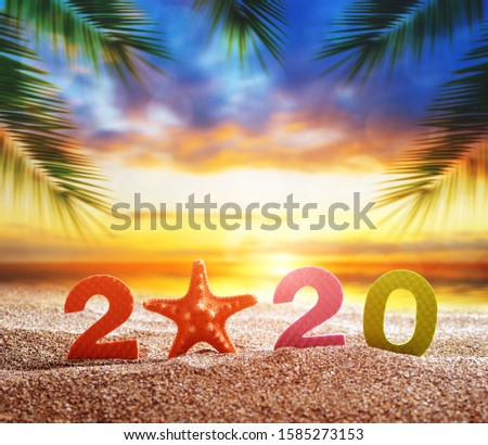 Number 2020 and starfish on the sand beach. Happy New Year and  summer holiday concept.