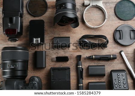 Flat lay composition with equipment for professional photographer on wooden table