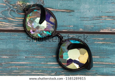 glasses with kaleidoscope lenses on a wooden blue background