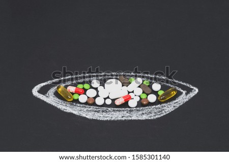 medicines in a painted plate on a black Board