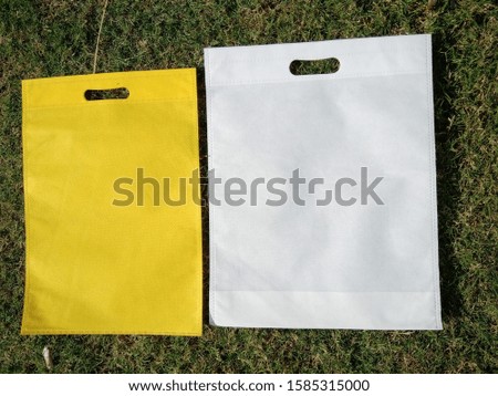 2 Amazing Colorful Non Woven Eco Friendly Bags on Green Grass Background. Shopping & Gift Bags