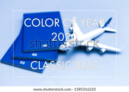 Minimal simple flat lay with plane passport sunglasses globe gold credit card and shell colored in trendy color of year 2020 Classic Blue. Tourist essentials. Vacation travel adventure trip concept