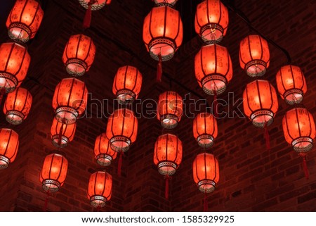 Background of many red lanterns hanging inside Chinese city walls. Text translation on lantern，Ancient Chinese characters: blessing,Good luck