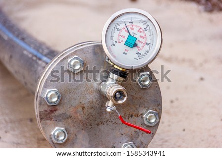 View of the hydrostatic testing of polyethylene pipeline and manometer (pressure gauge). EN 837-1 is a standard to produce for manometer. Cl 1,0 is a class of gauge. Bar (psi) is pressure unit.