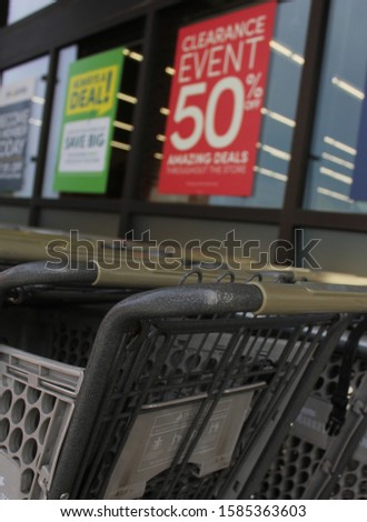 Shopping Cart With 50% Off Clearance Sign in Background