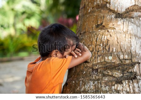 Filipino boy playing hide and seek at the beach of Port Barton - Palawan - Philippines