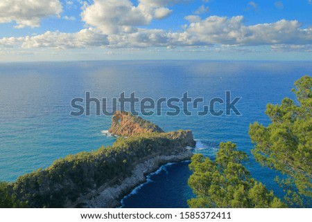 Photo taken on the island of Palma de Mallorca. The picture shows a seascape with a long cape in the foreground.