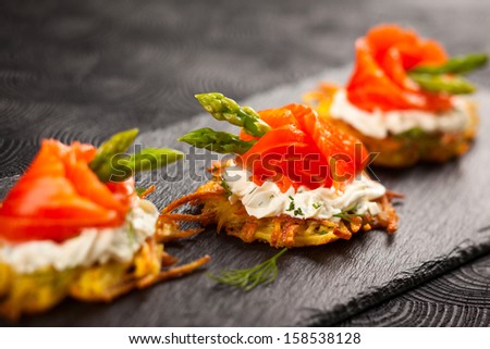Potato pancakes topped with smoked salmon,asparagus and sour cream for holiday
