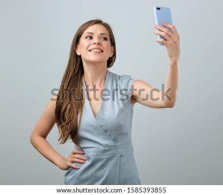 smiling young woman holding smartphon in front of face for selfie. isolated female portrait.