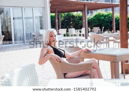 blonde girl sitting at the beach restaurant