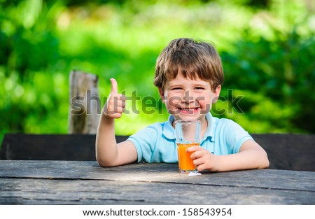 Yang little and cute boy pictured with glass of juice.