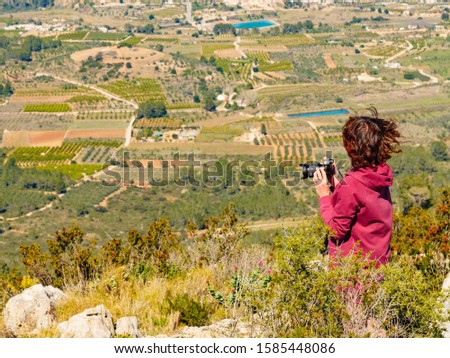 Tourist woman take travel picture from mountains landscape in Spain. Coll de Rates cycling route, view on the way up. Costa Blanca holiday
