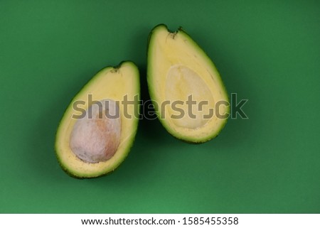 Avocado stock photo. Halved avocado stock images. Avocado isolated on a green background