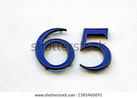 House number 65 in 3D on a white wall